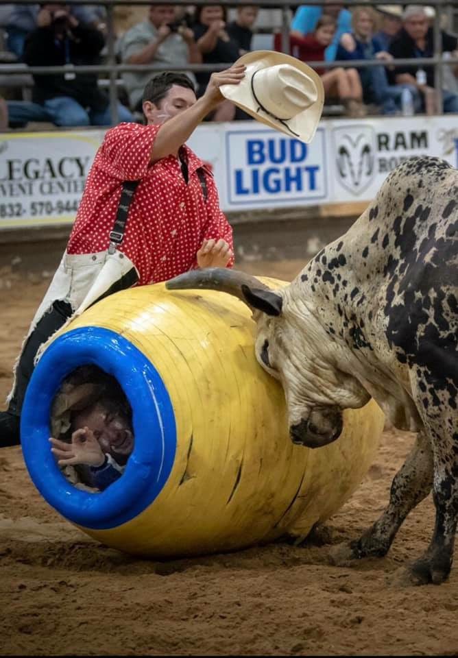 A bull and its rider in the middle of an obstacle course.